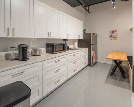 The studio kitchen with coffee maker, microwave and a table