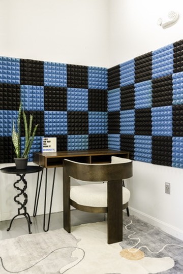 A private room with a desk and blue and black sound panels for virtual sessions